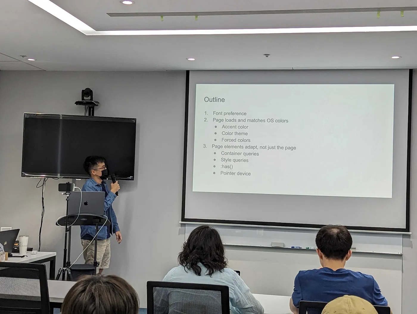 一名男子在講台上分享簡報