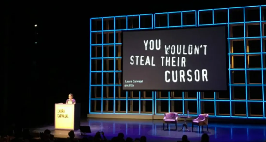 Laura在講台上演講，後面的簡報寫著大大的You Wouldn t steal their cursor.